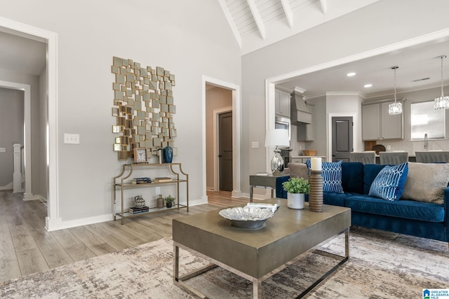 living room with lofted ceiling with beams, light wood-style floors, baseboards, and recessed lighting