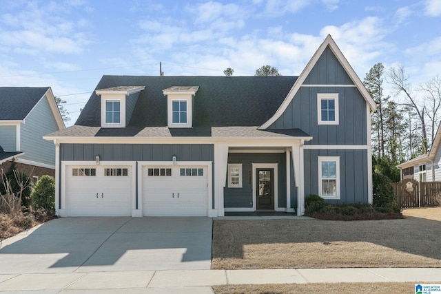 modern inspired farmhouse featuring a shingled roof, concrete driveway, board and batten siding, fence, and a garage