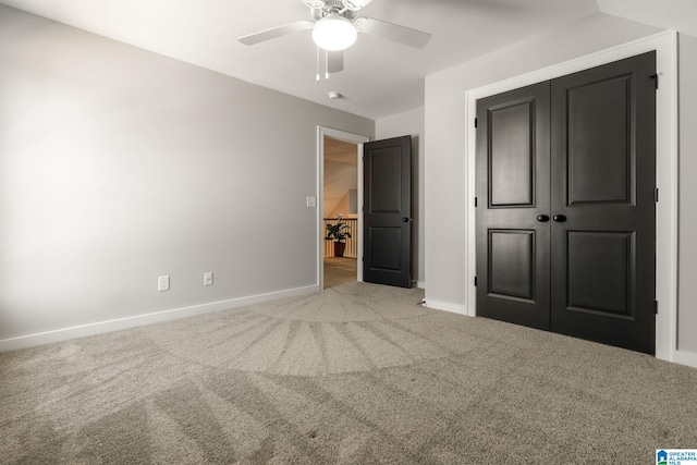 unfurnished bedroom featuring ceiling fan, a closet, carpet flooring, and baseboards