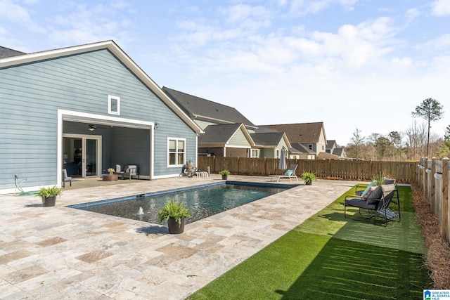 view of pool featuring a patio, a fenced backyard, a ceiling fan, french doors, and a fenced in pool