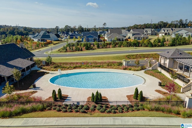 view of swimming pool featuring a residential view and fence