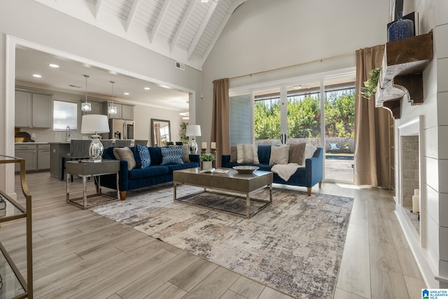 living area featuring light wood finished floors, visible vents, beamed ceiling, high vaulted ceiling, and recessed lighting