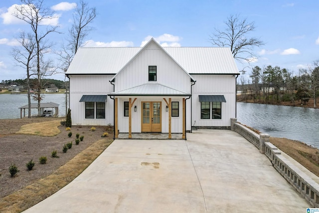 modern farmhouse style home with metal roof, french doors, and a water view