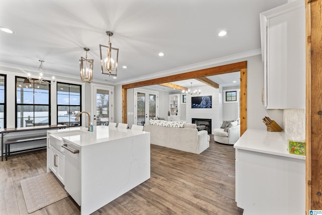 1165 Cedar Creek Dr, Sylacauga, AL 35151 - kitchen with a large fireplace, dark wood-style floors, and a notable chandelier