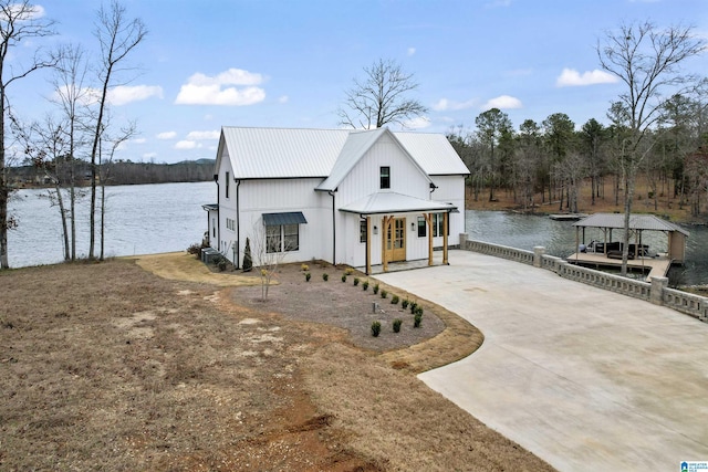 1165 Cedar Creek Dr, Sylacauga, AL 35151 - view of front of home with metal roof, a dock, a water view, and driveway