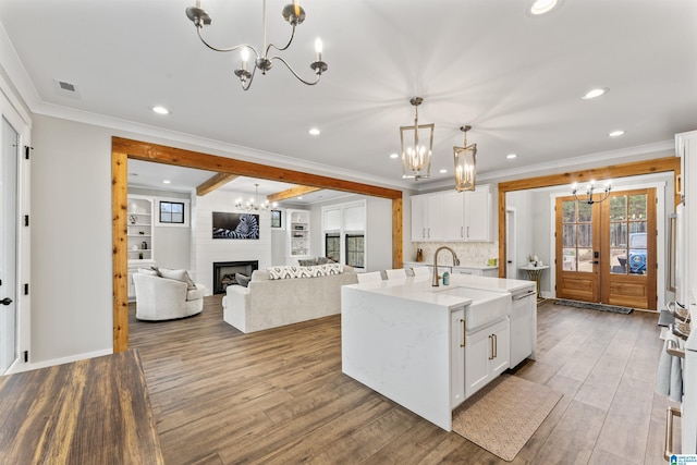 1165 Cedar Creek Dr, Sylacauga, AL 35151 - kitchen with a notable chandelier, a fireplace, wood finished floors, a sink, and crown molding
