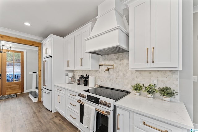 1165 Cedar Creek Dr, Sylacauga, AL 35151 - kitchen featuring white appliances, white cabinets, custom range hood, wood finished floors, and backsplash