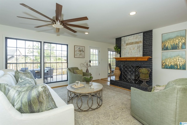 living room with recessed lighting, wood finished floors, a brick fireplace, and ceiling fan