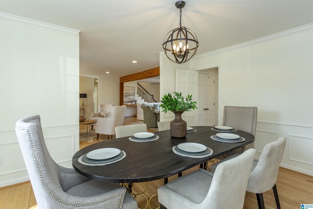 dining area featuring light wood finished floors, a decorative wall, crown molding, stairway, and a notable chandelier