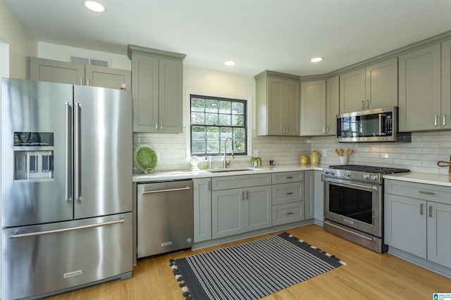 kitchen featuring visible vents, gray cabinetry, light countertops, stainless steel appliances, and a sink