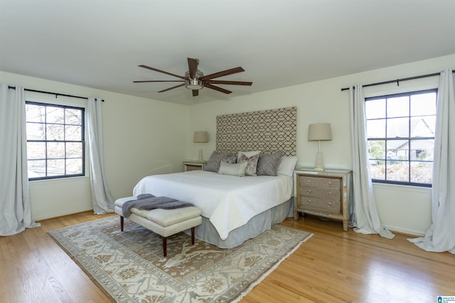 bedroom with baseboards, light wood-style floors, and ceiling fan