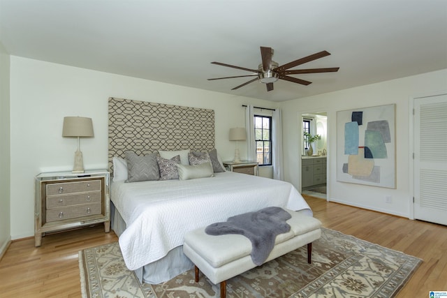 bedroom featuring ceiling fan, connected bathroom, baseboards, and light wood-style flooring