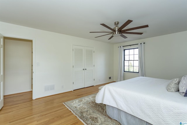 bedroom featuring a ceiling fan, visible vents, baseboards, a closet, and light wood-type flooring