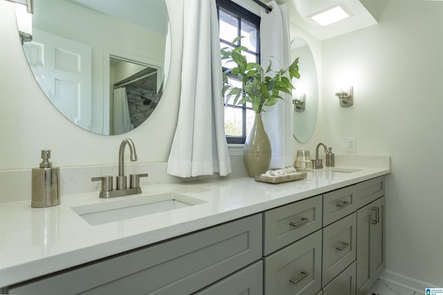 full bathroom with marble finish floor, a healthy amount of sunlight, and a sink