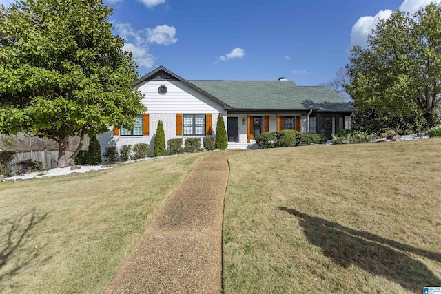 view of front facade featuring brick siding and a front yard