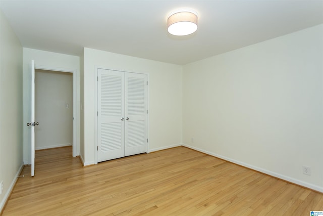 unfurnished bedroom featuring a closet, baseboards, and light wood-style floors