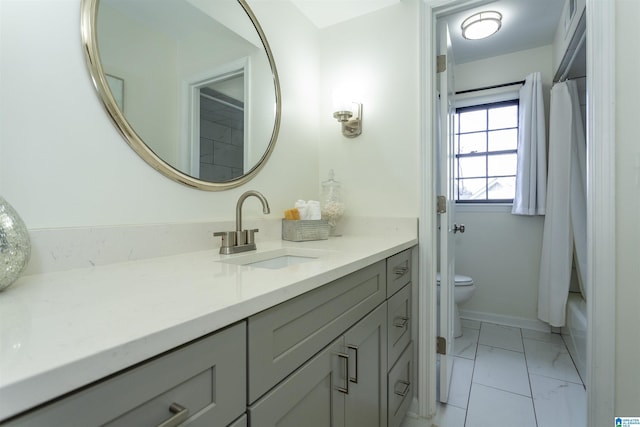 bathroom with baseboards, toilet, marble finish floor, and vanity