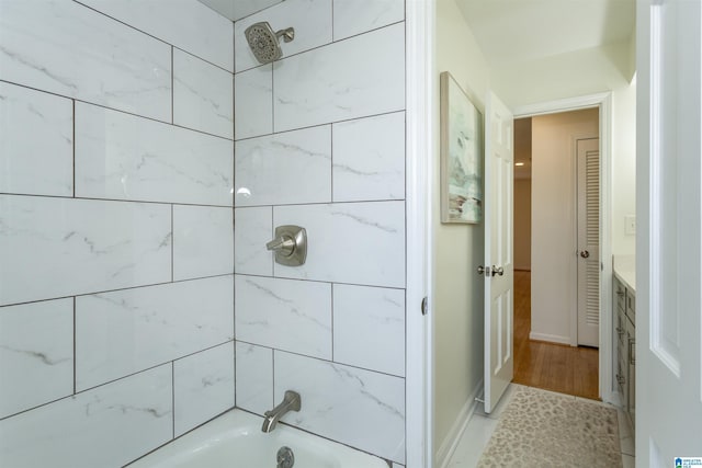 bathroom with shower / bathing tub combination, baseboards, and vanity