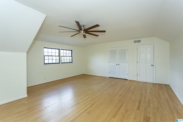 bonus room featuring visible vents, light wood-style flooring, a ceiling fan, baseboards, and lofted ceiling