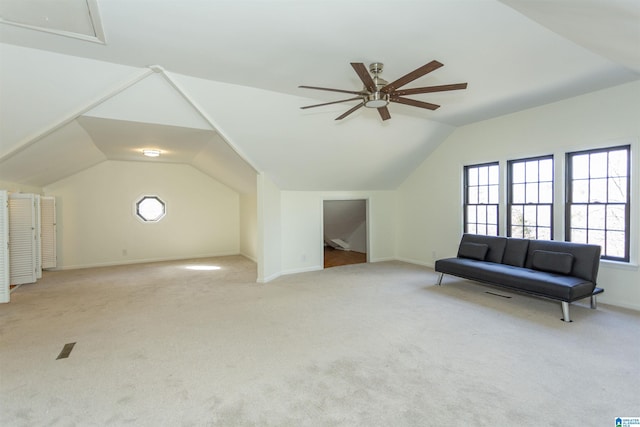 additional living space with vaulted ceiling, a ceiling fan, baseboards, and light carpet