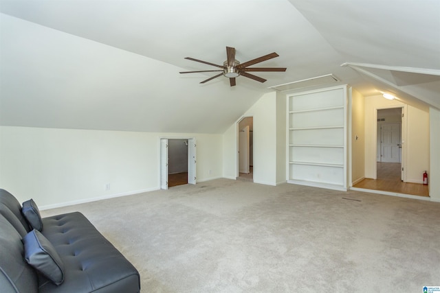 bonus room with built in shelves, attic access, ceiling fan, and carpet flooring