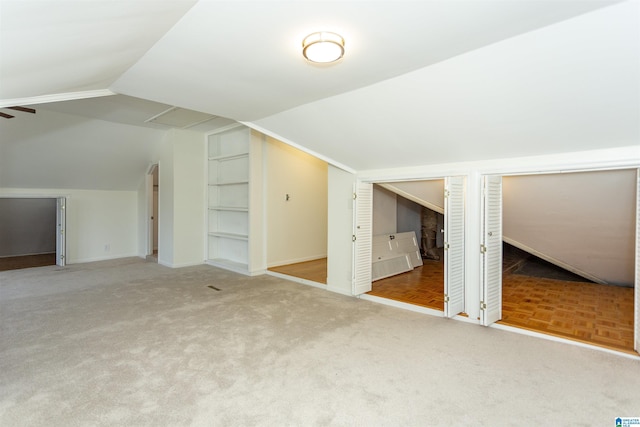 bonus room with ceiling fan, baseboards, lofted ceiling, and carpet