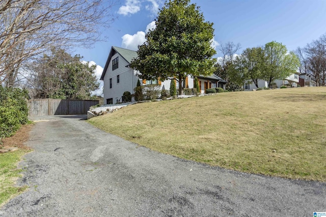 view of front of home with a front lawn and fence