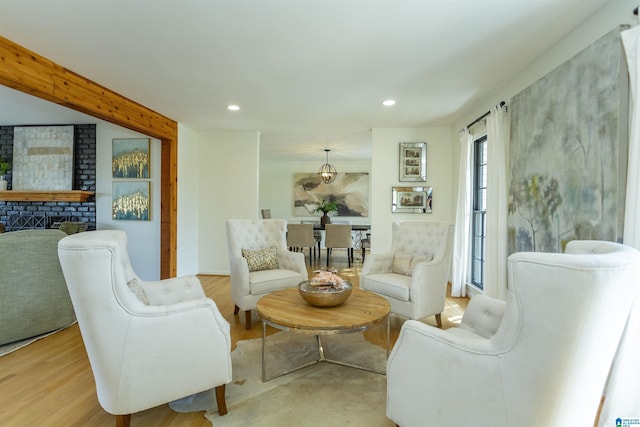 living room featuring light wood finished floors, recessed lighting, and a fireplace