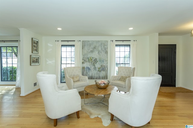 living area featuring recessed lighting, baseboards, and light wood finished floors