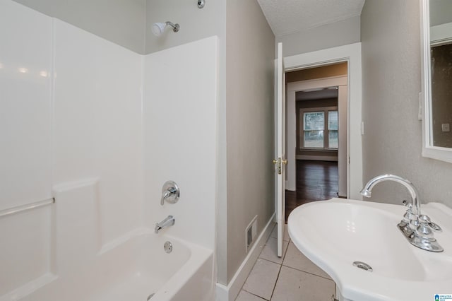 bathroom featuring visible vents, bathing tub / shower combination, tile patterned floors, a textured ceiling, and a sink