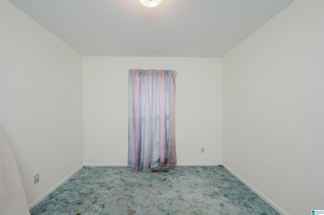 carpeted spare room featuring baseboards