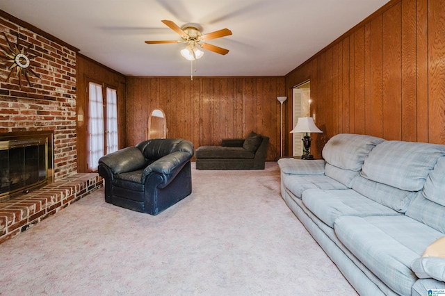 living room with wooden walls, ceiling fan, french doors, carpet floors, and a brick fireplace