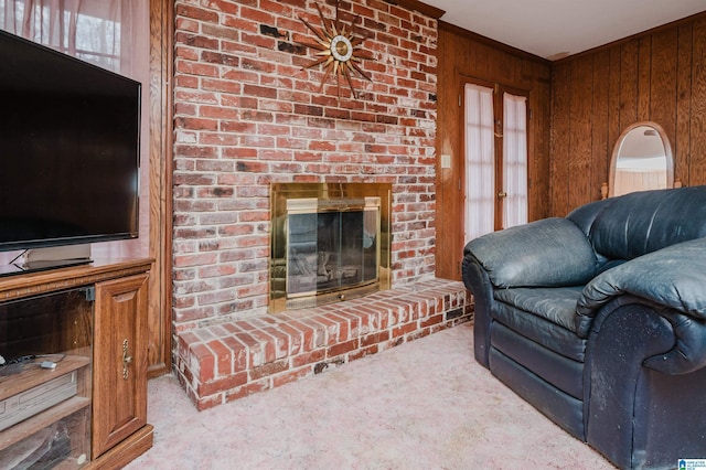 carpeted living area featuring crown molding, a fireplace, and wooden walls