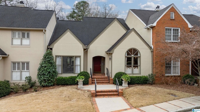 view of front of home featuring roof with shingles and stucco siding