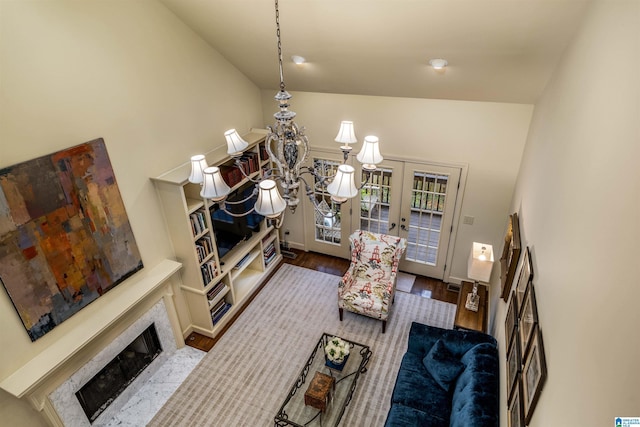 dining area with wood finished floors, french doors, baseboards, a fireplace, and lofted ceiling