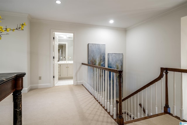 corridor with baseboards, carpet floors, recessed lighting, crown molding, and an upstairs landing