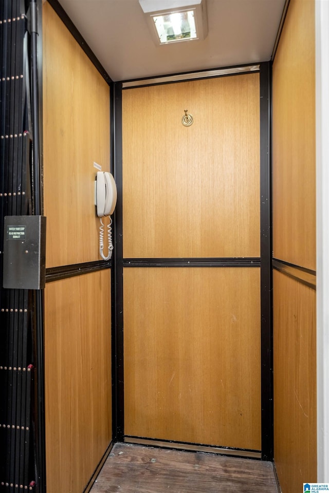 interior details featuring elevator and wood finished floors