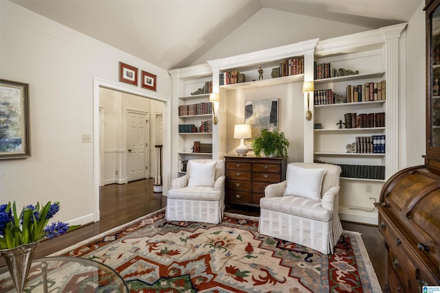 living area with baseboards, lofted ceiling, and wood finished floors