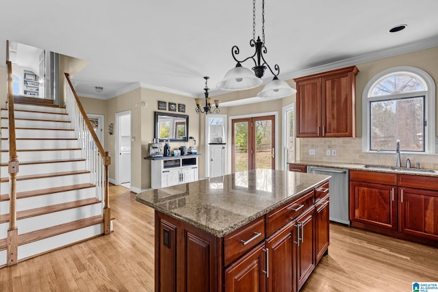 kitchen featuring light wood finished floors, crown molding, french doors, stainless steel dishwasher, and a sink