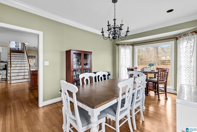 dining room with baseboards, wood finished floors, an inviting chandelier, stairs, and crown molding