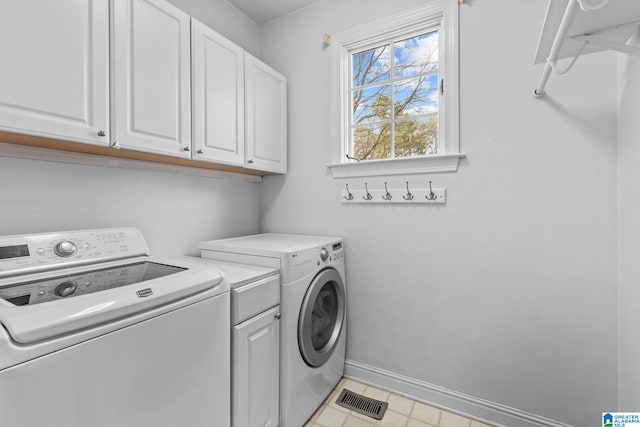 washroom featuring cabinet space, visible vents, baseboards, and separate washer and dryer