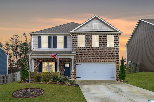 view of front facade with brick siding, a front yard, fence, a garage, and driveway