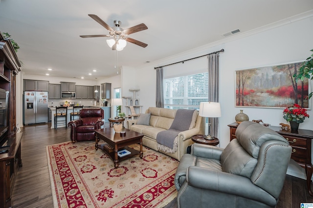 living room featuring recessed lighting, visible vents, a ceiling fan, ornamental molding, and dark wood finished floors