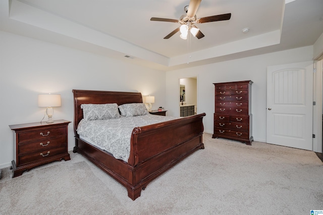 bedroom with carpet floors, a tray ceiling, baseboards, and a ceiling fan