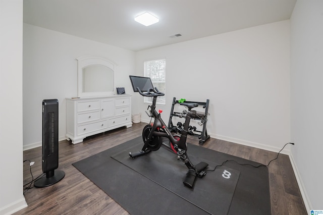 exercise room with dark wood-type flooring, visible vents, and baseboards