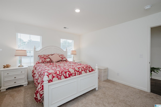 carpeted bedroom with visible vents and baseboards