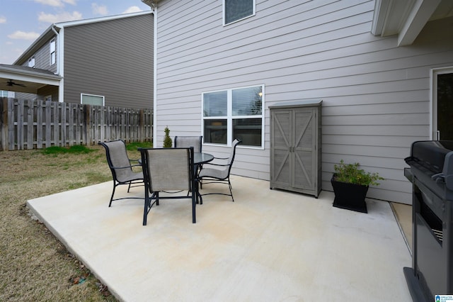 view of patio featuring outdoor dining area, grilling area, and fence