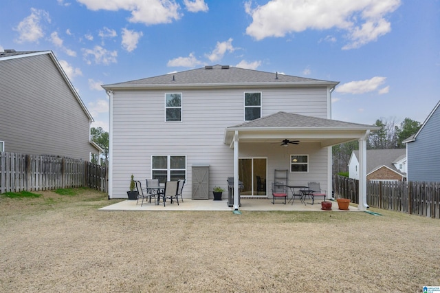 back of property with ceiling fan, a shingled roof, a patio area, and a fenced backyard