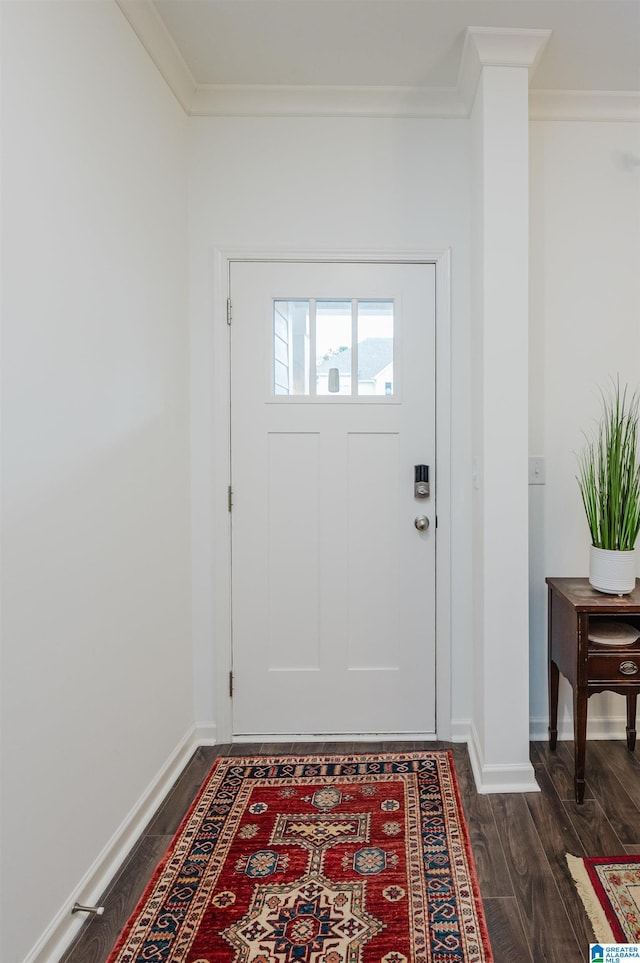 doorway featuring dark wood-type flooring, crown molding, and baseboards