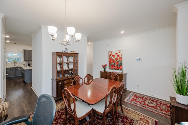 dining room with ornamental molding, dark wood-type flooring, an inviting chandelier, and baseboards